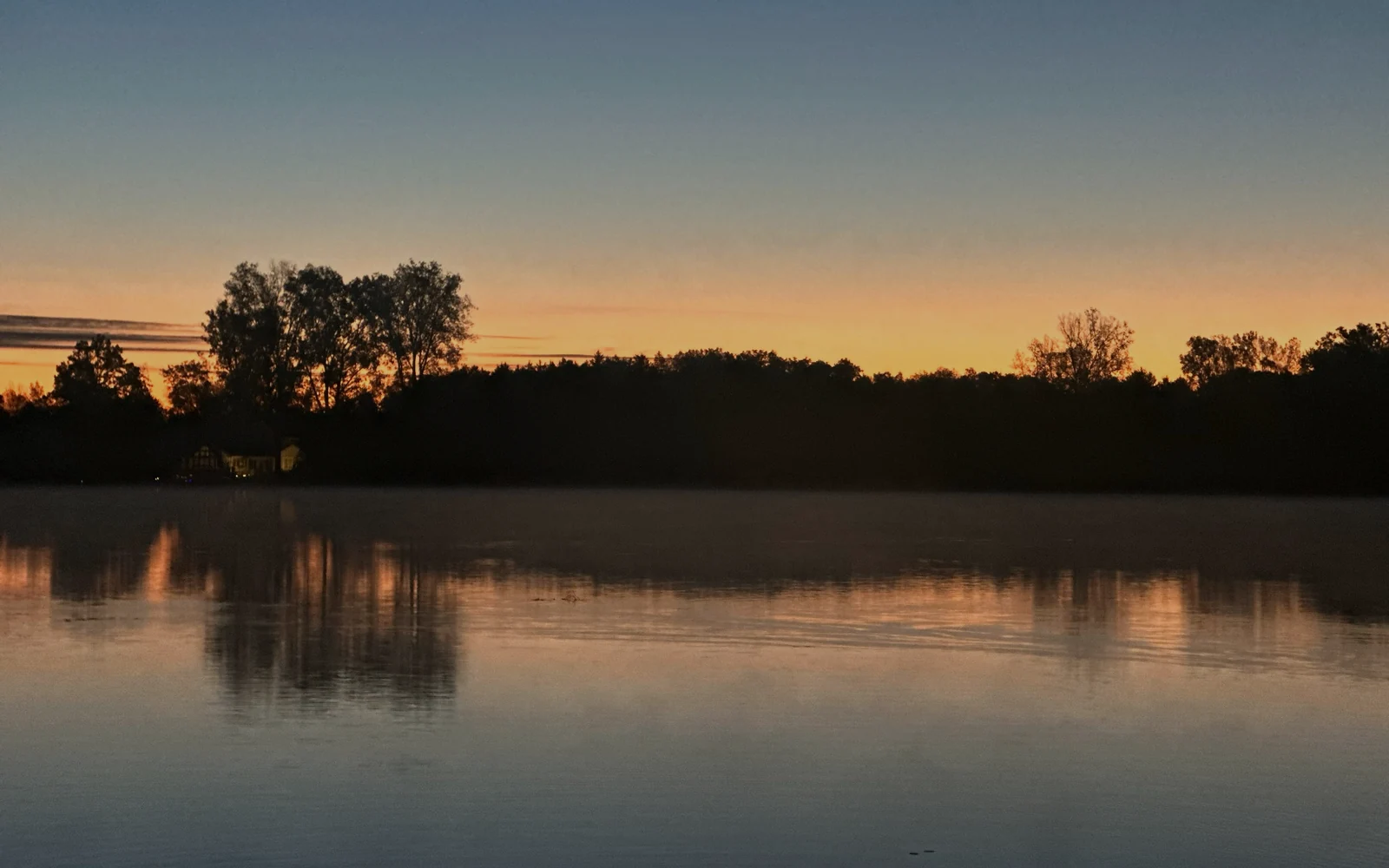 Calm lake at dusk representing financial stabilization and clear reflection
